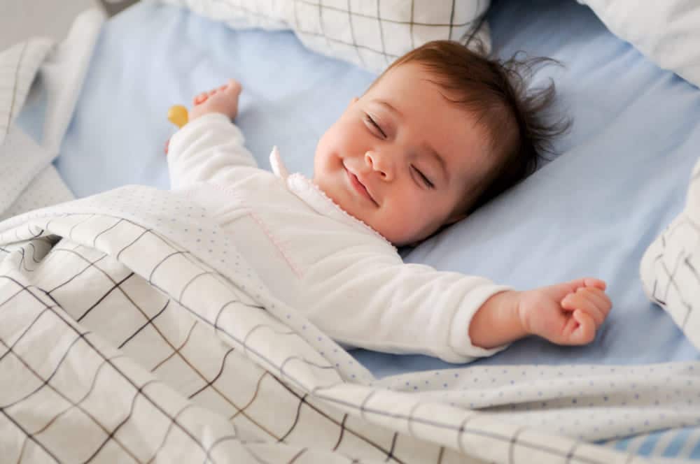 young child sleeping peacefully on a baby mattress